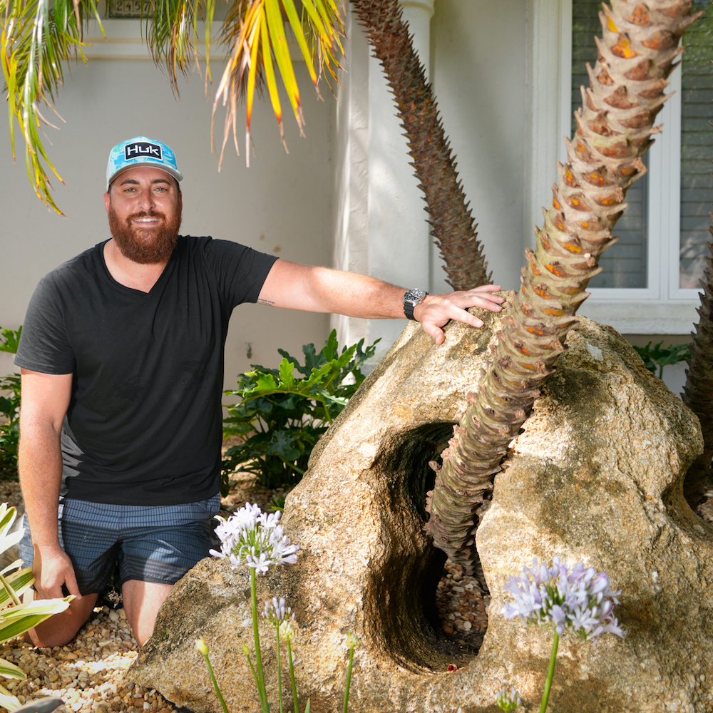 Founder, Chris, standing against a Palm tree