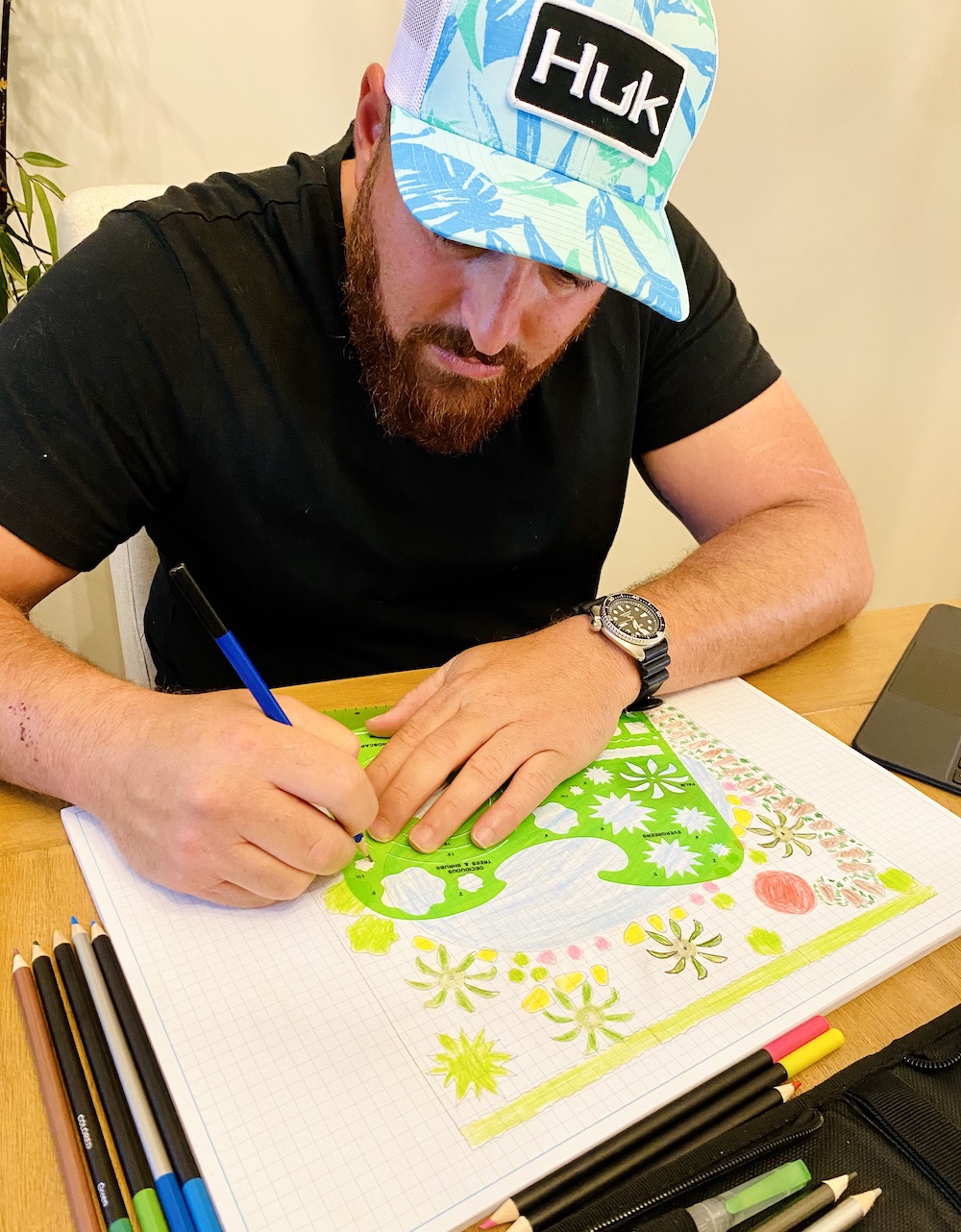 Chris in the field, clipboard in hand, inspecting and fine-tuning elements of a newly implemented landscape design to ensure it meets the highest standards