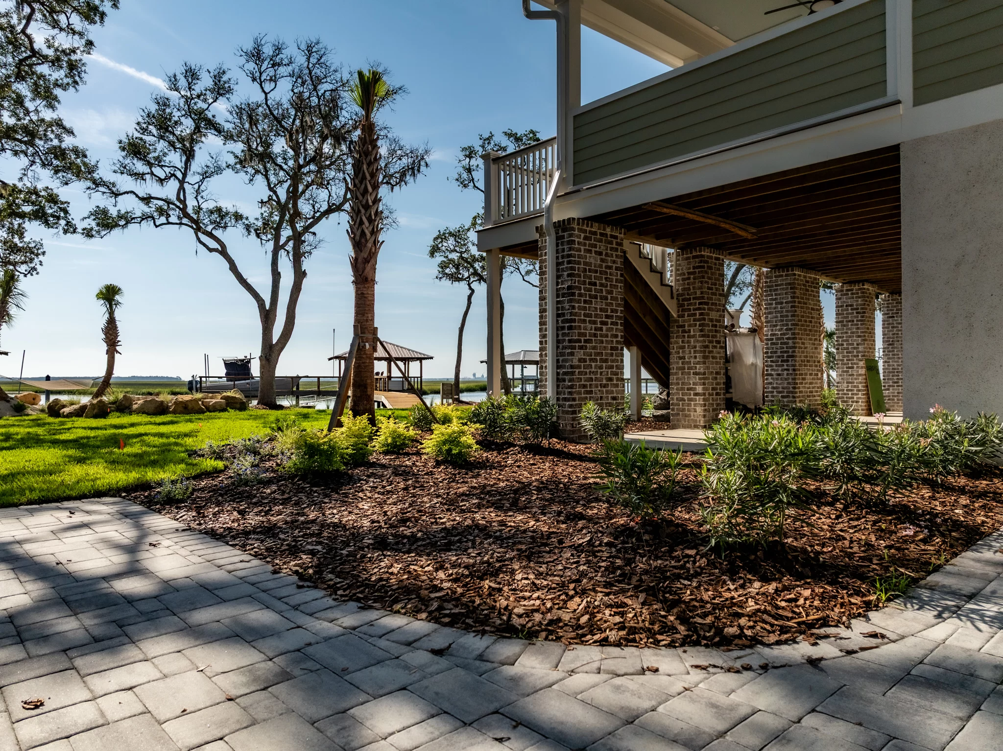 Atlantic Coast Patio Coastal patio installation in St. Mary’s Georgia with pavers, palms, and lounge space
