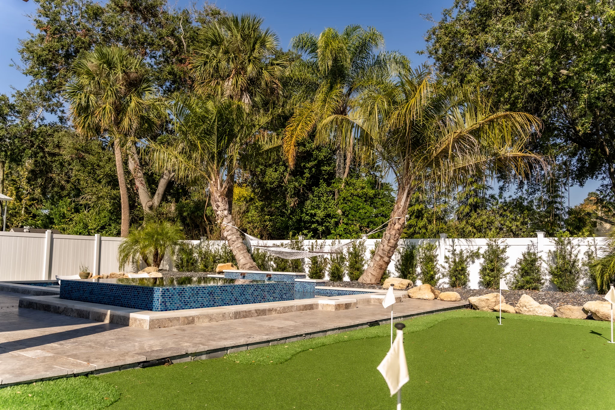 Fire Pit Lounge Custom fire pit lounge in Jacksonville Beach with premium stonework and tropical plantings