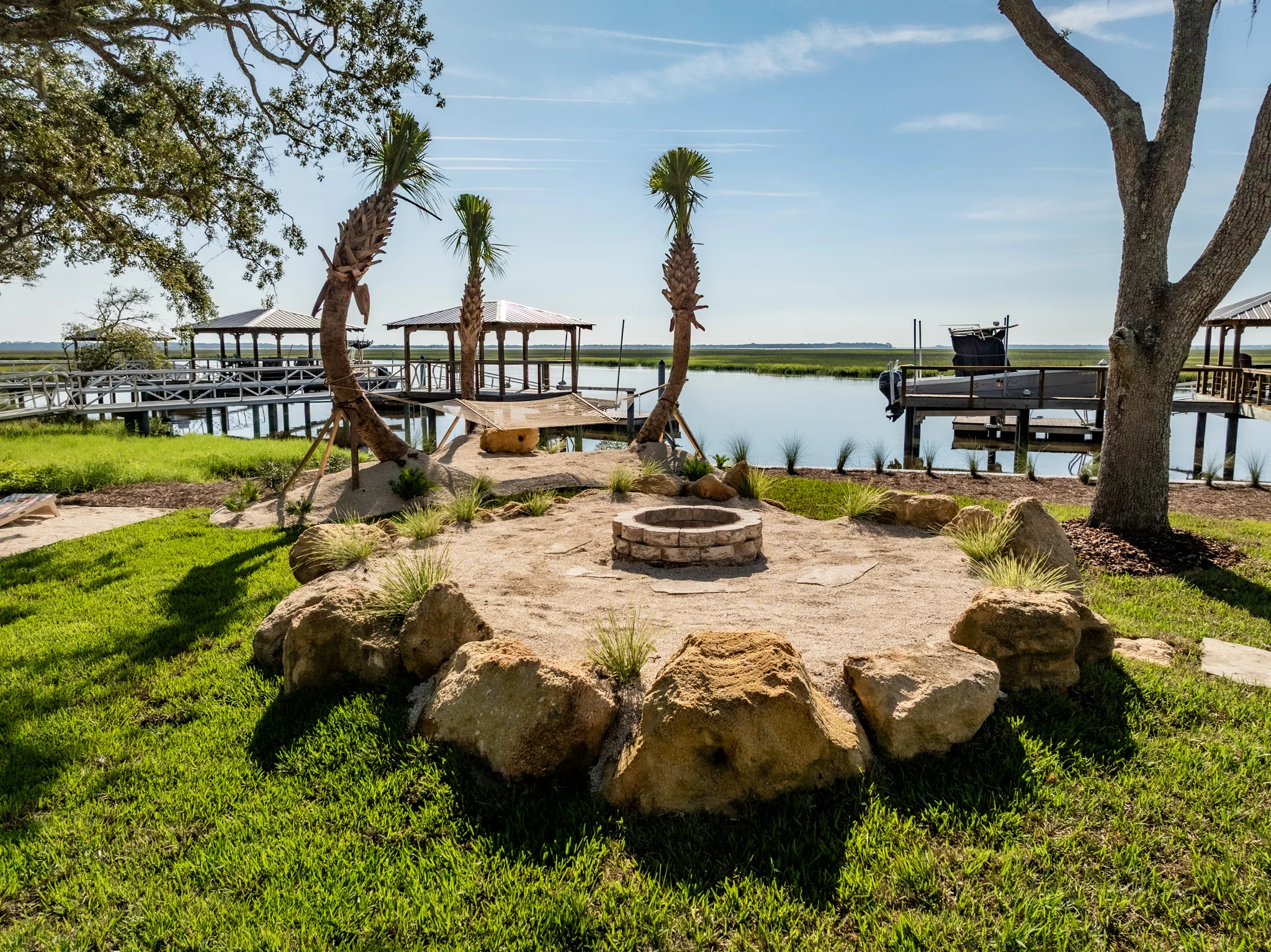 Luxury Fire Features Built for Coastal Outdoor Living A meticulously arranged rock border separating flower beds from the lawn, adding a rustic touch to the garden